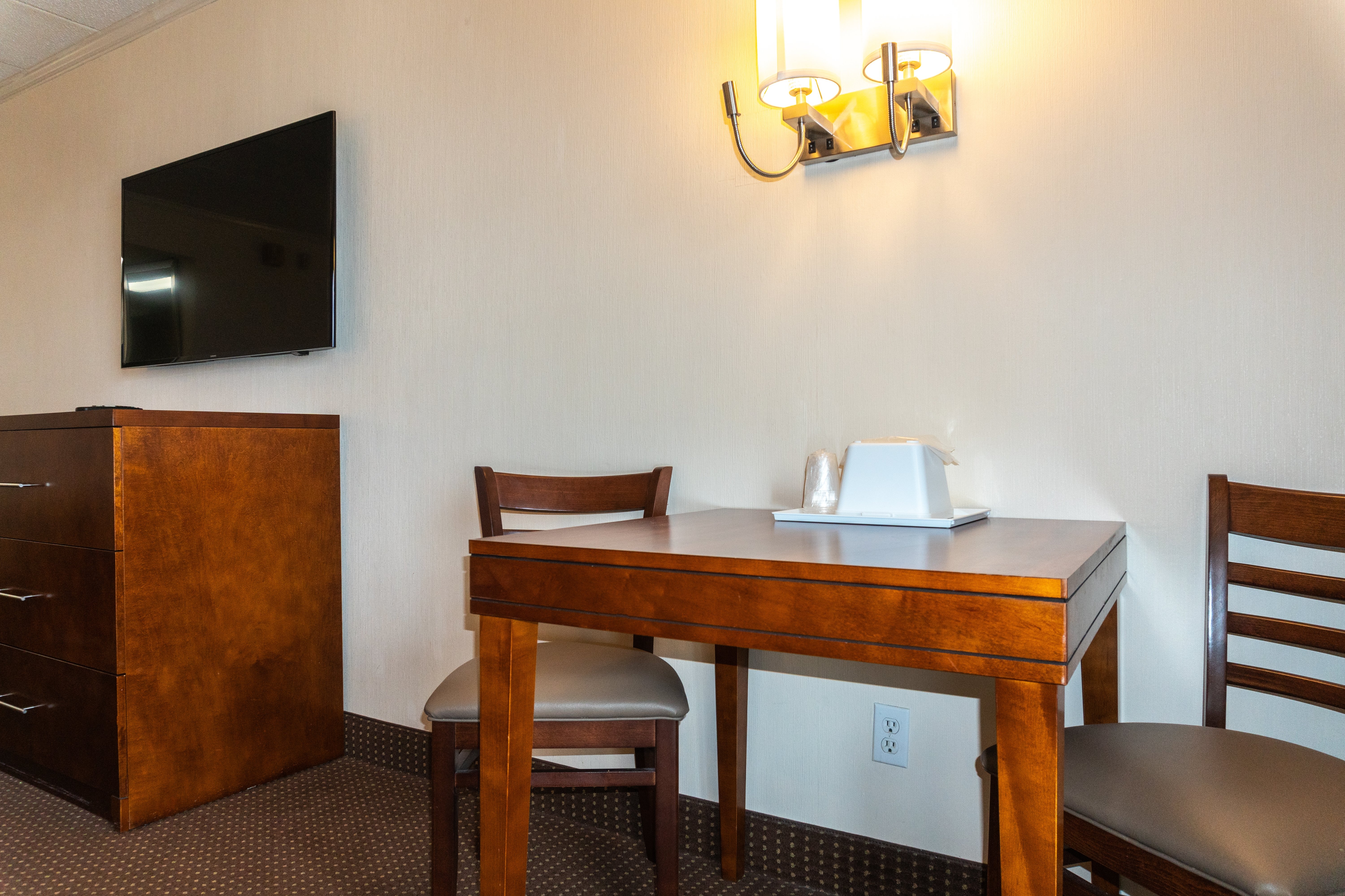 hotel room table and chairs with large tv